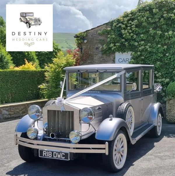 Roxy, the two tone silver wedding car, outside an ivy-covered cottage